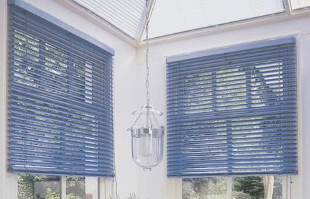 Una habitación con persianas azules en las ventanas y una lámpara de araña colgando del techo.