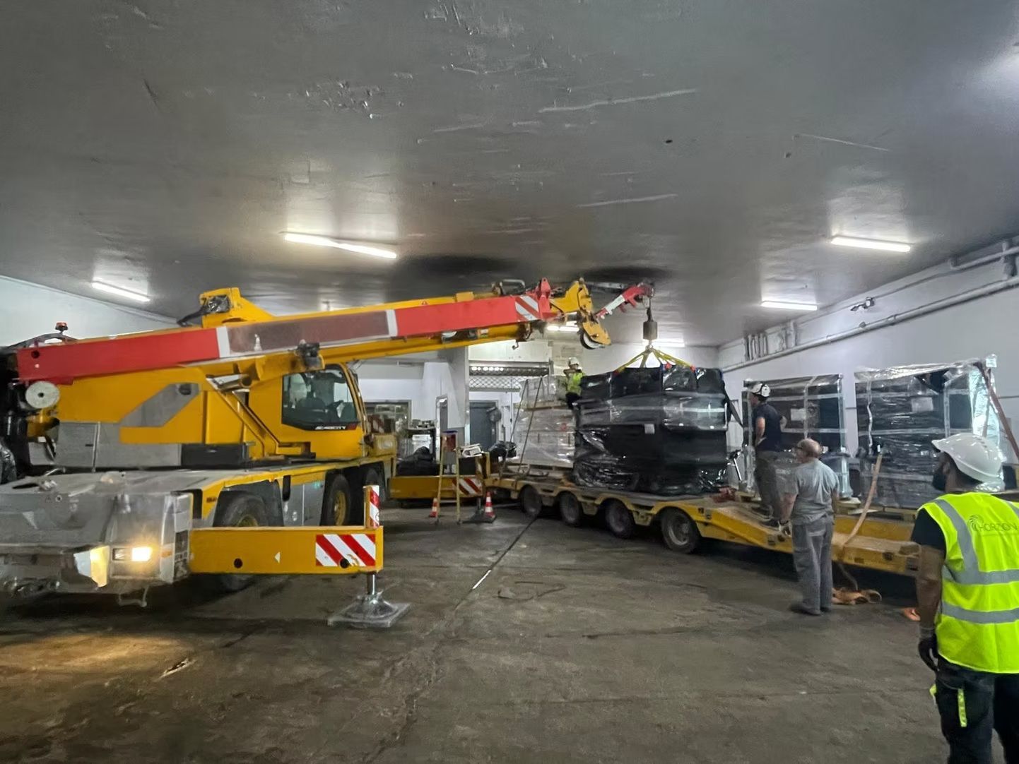 Une grue de forte capacité charge du matériel sur une remorque