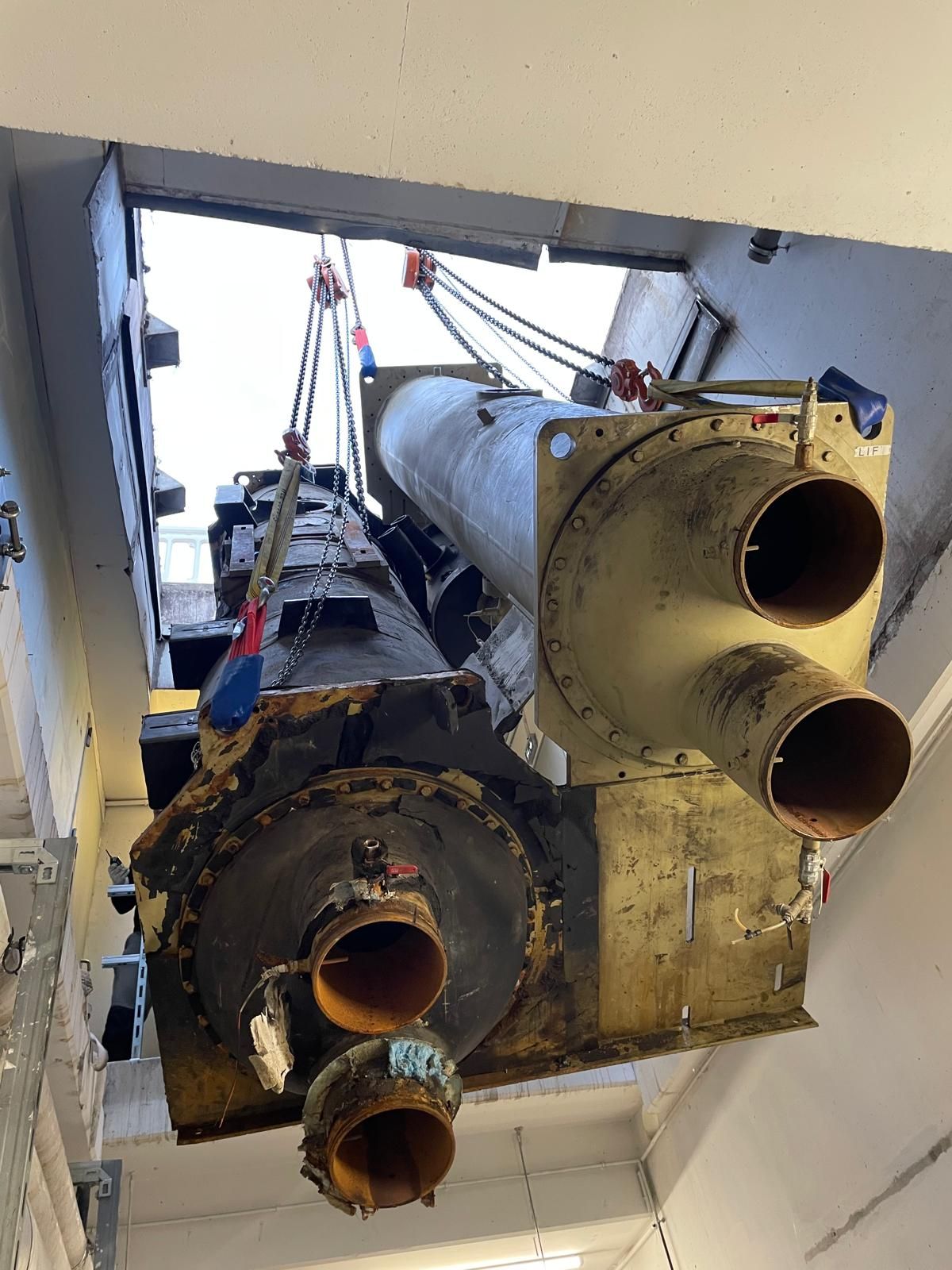 Des machines industrielles en cours de levage à travers une porte