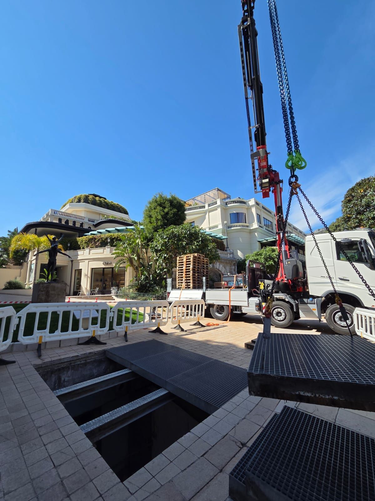Chantier avec un camion-grue à côté d’un bâtiment sous un ciel bleu