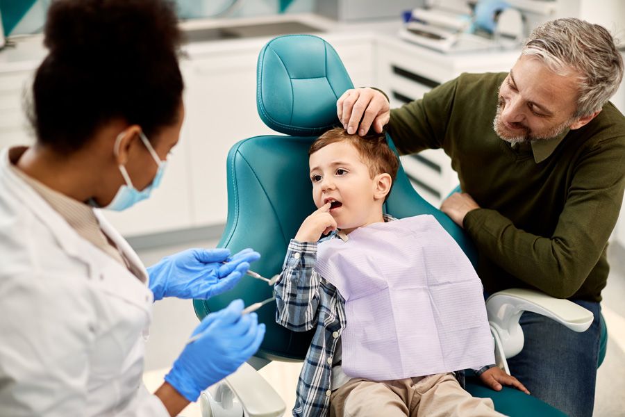 Petit garçon sur un fauteuil bleu chez le dentiste