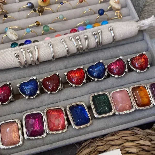 Una variedad de anillos y pulseras en una vitrina.
