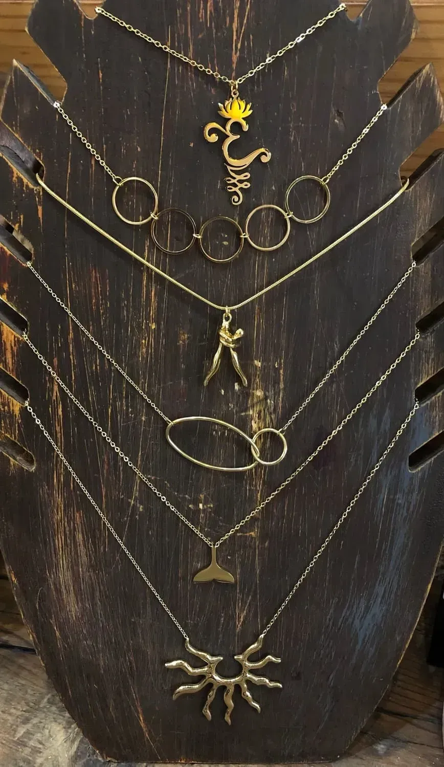 Una exhibición de collares en un maniquí de madera.