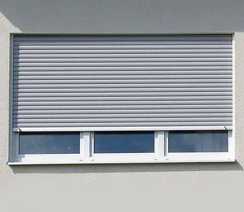 Una ventana blanca con una persiana gris.