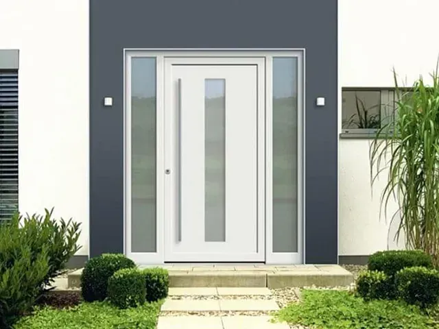 Una puerta blanca con muchas ventanas está frente a una casa.