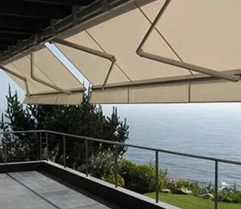 Un balcón con un gran toldo con vista al mar.