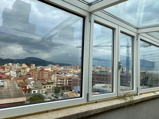 Una ventana con vista a una ciudad y montañas.