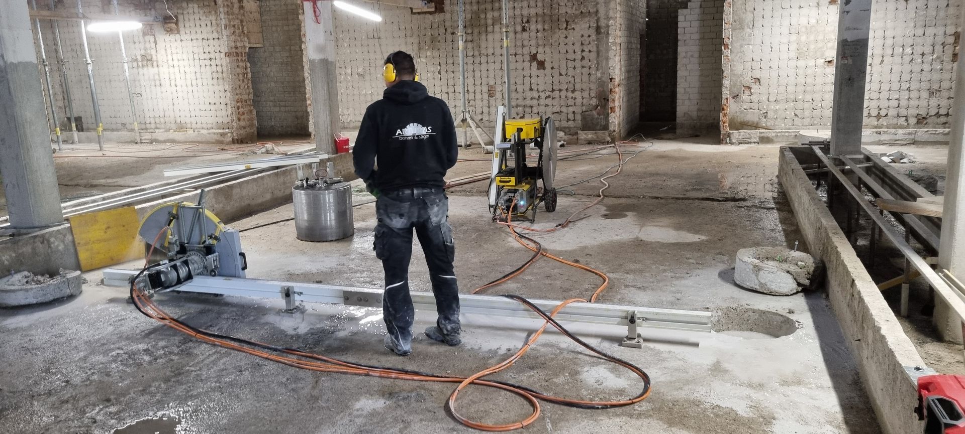 Mitarbeiter von Arturas auf einer Baustelle, bedient eine Säge