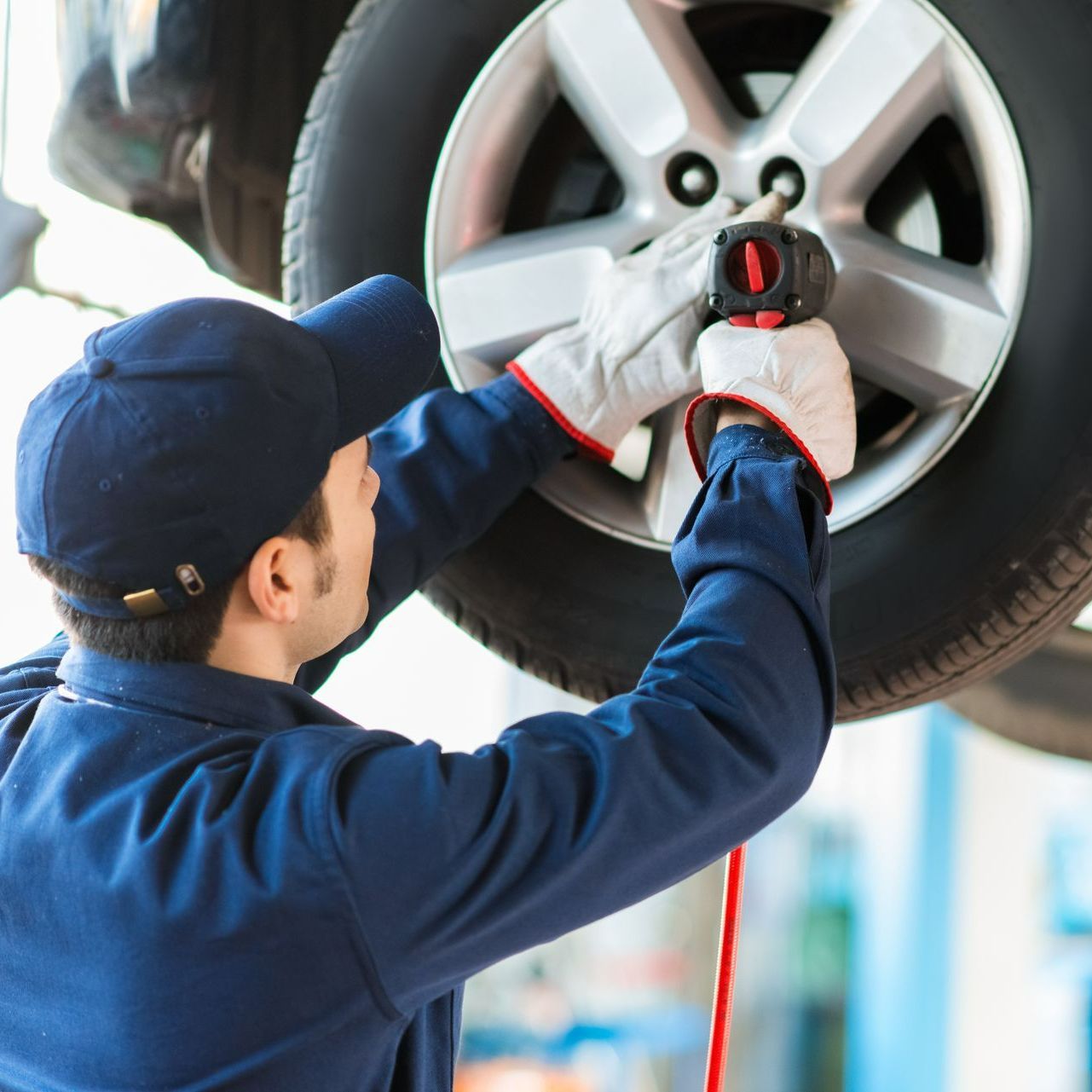 Un garagiste change le pneu d'une voiture à l'aide d'un outil