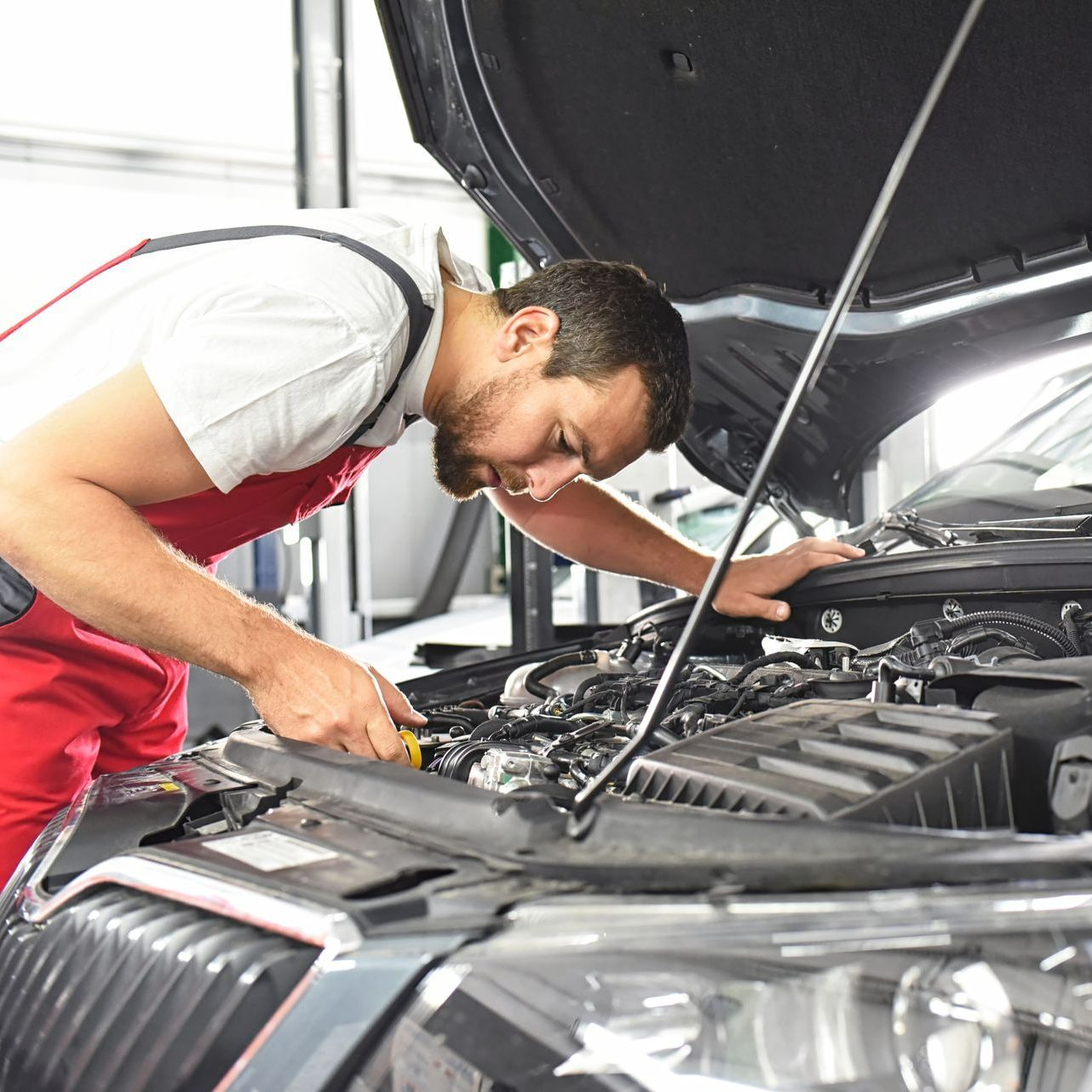Un garagiste inspecte le moteur d'une voiture 