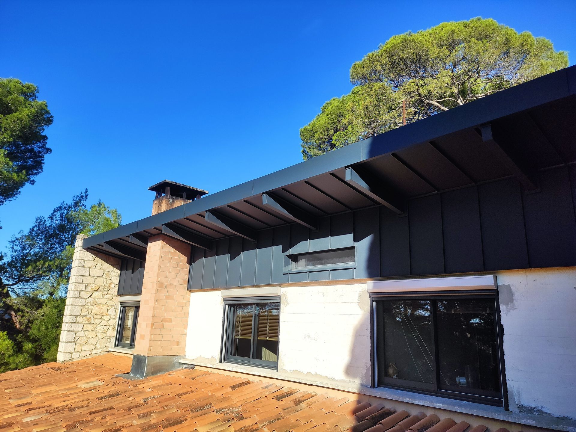 Un dessous de toit vu du dessous recouvert d'un habillage en métal