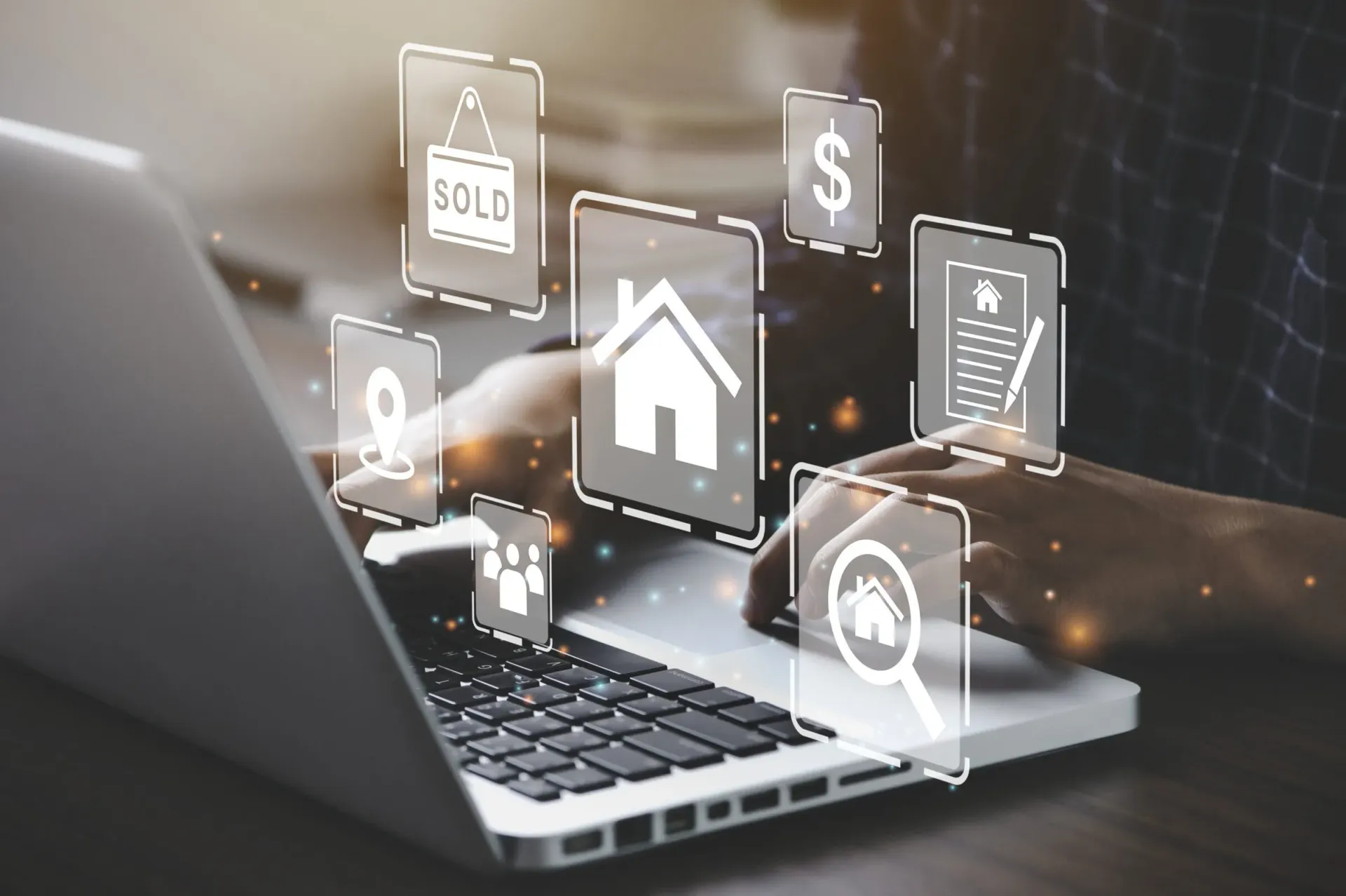 Persona que usa una computadora portátil con íconos inmobiliarios flotantes, probablemente buscando.