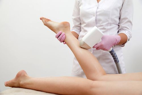 Una mujer está recibiendo un tratamiento de depilación láser en las piernas.