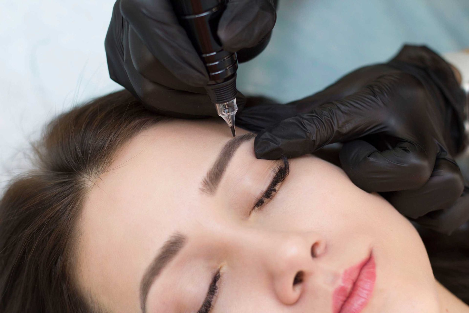 Una mujer se está haciendo un tatuaje de maquillaje permanente en las cejas.