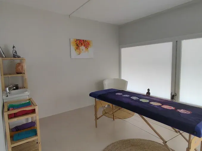 Una habitación con una mesa de masajes y una silla