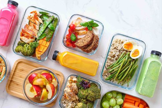 Hay muchos tipos diferentes de alimentos en los recipientes sobre la mesa.
