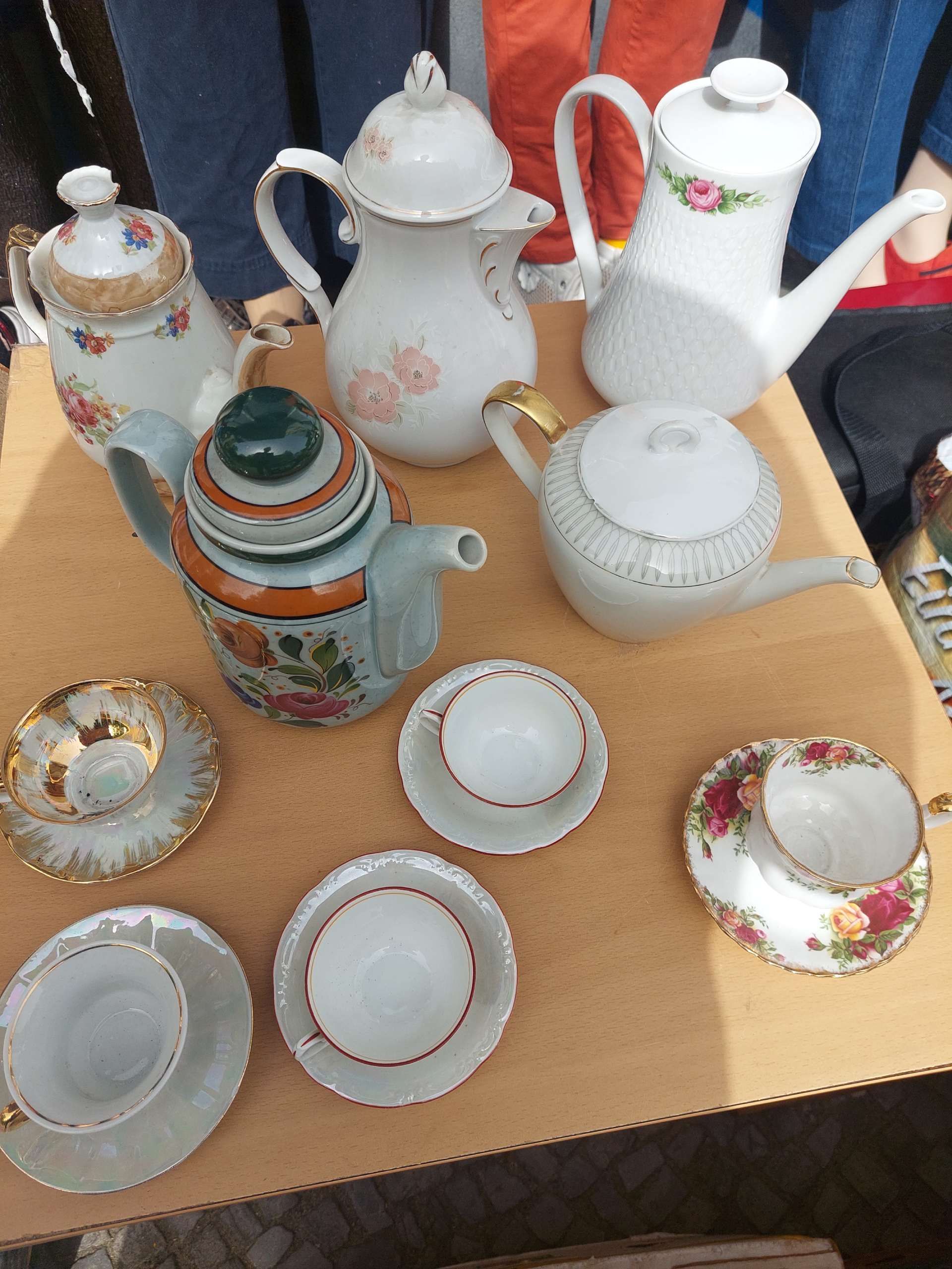 verschiedene antike Porzellantassen mit Untersetzer und Teekannen
