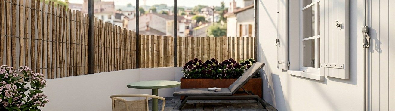 Terrasse urbaine : dallage de pierre, jardinières en acier et occultation en bambou