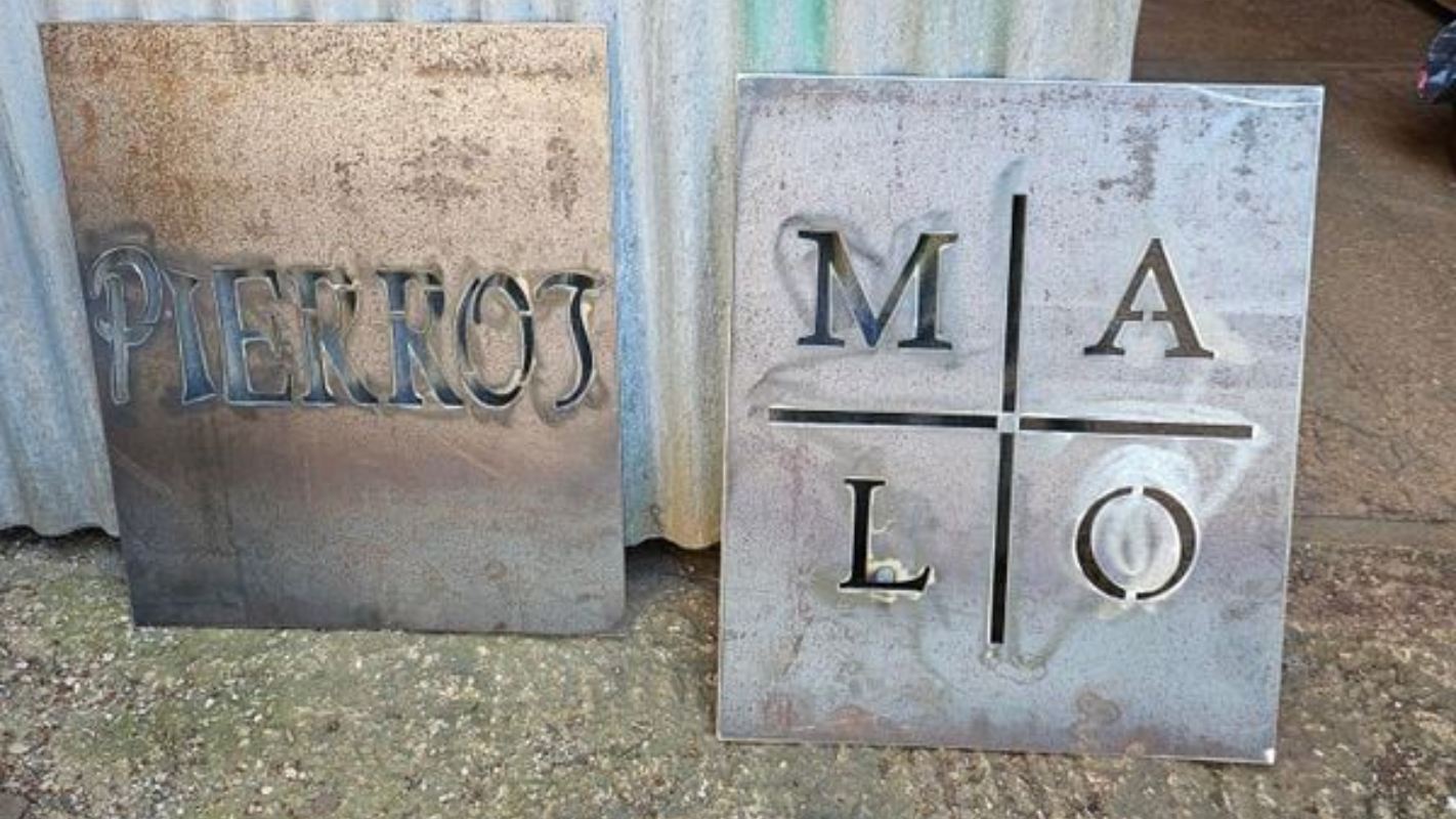 Deux plaques métalliques avec des lettres découpées.