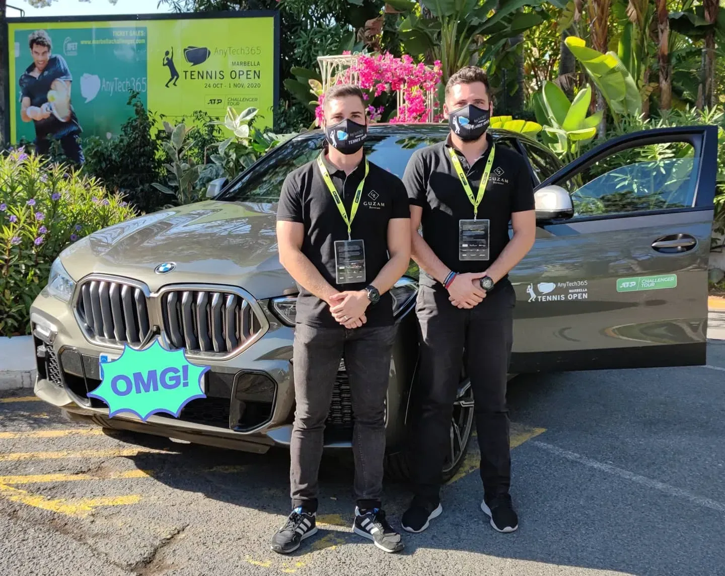 Dos hombres con máscaras faciales están parados frente a un automóvil.