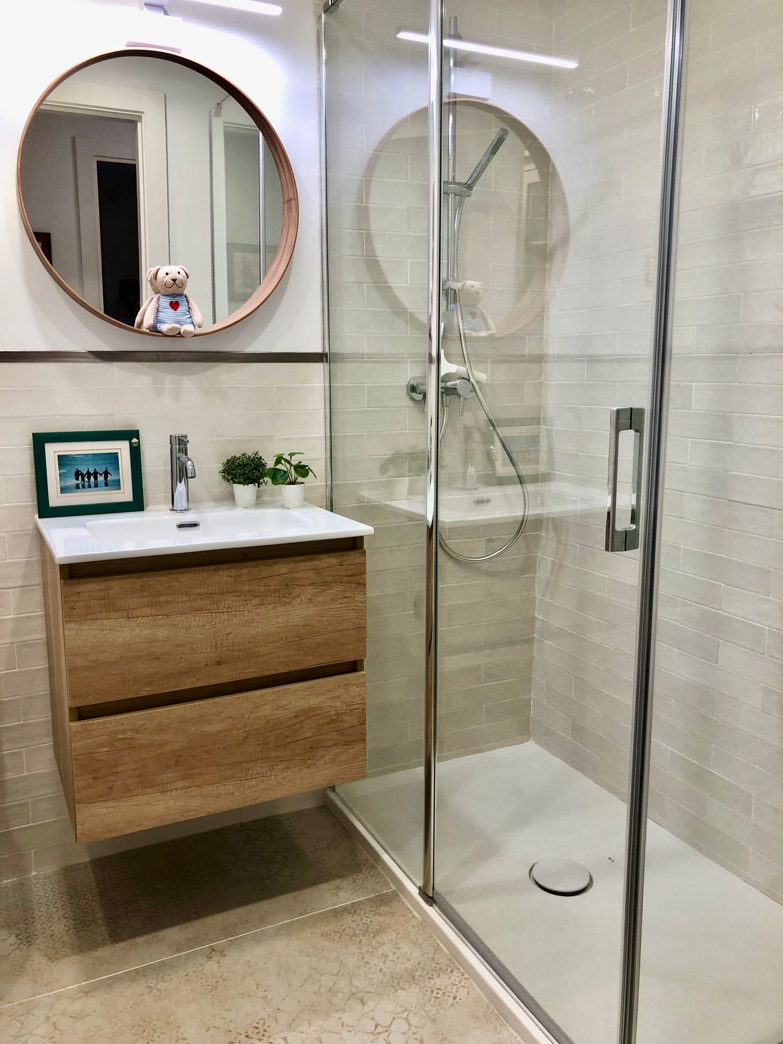Un baño con lavabo, ducha y espejo.