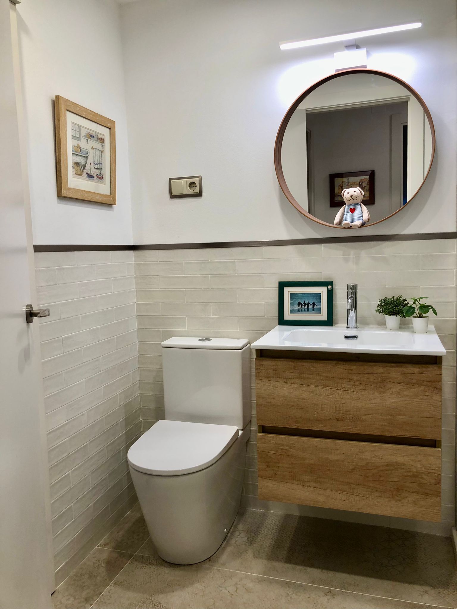 Un baño con inodoro, lavabo y espejo.