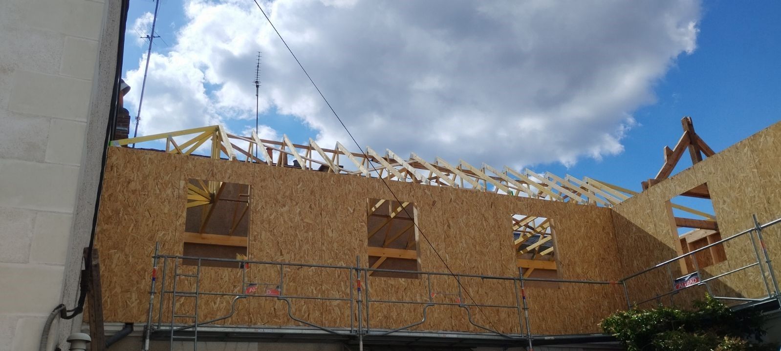 Maison à pans de bois avec un toit en bardeaux foncés.