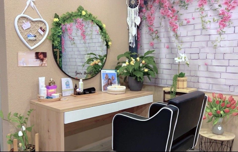 Une pièce avec une chaise, une table, un miroir et des fleurs.