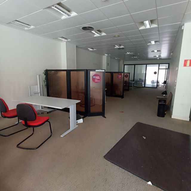 Una habitación con cubículos y un extintor rojo en la pared.