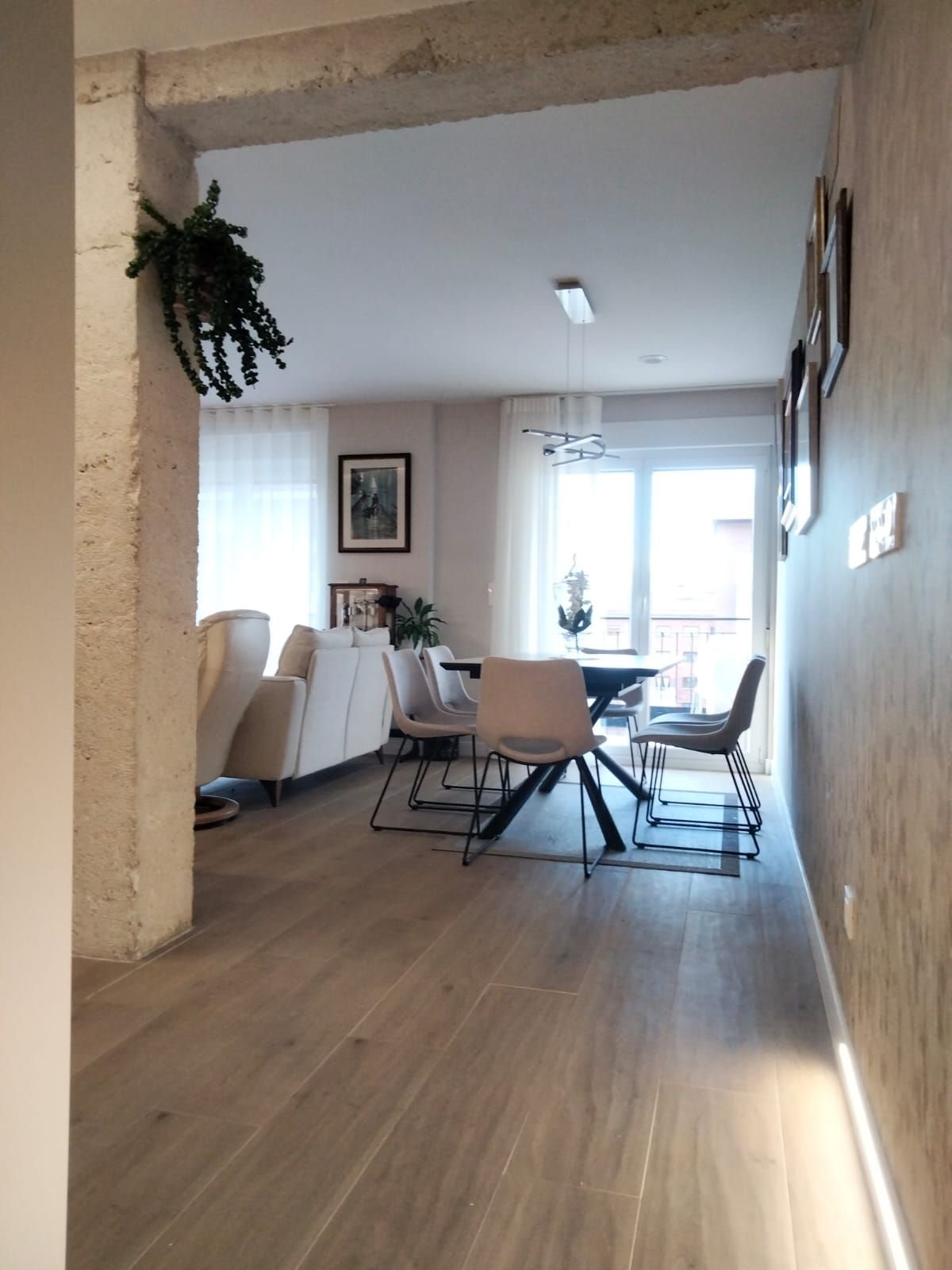 Un pasillo que conduce a un comedor con una mesa y sillas.