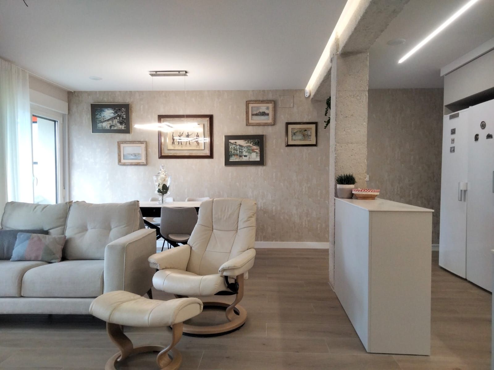 Una sala de estar con un sofá, una silla y una otomana.