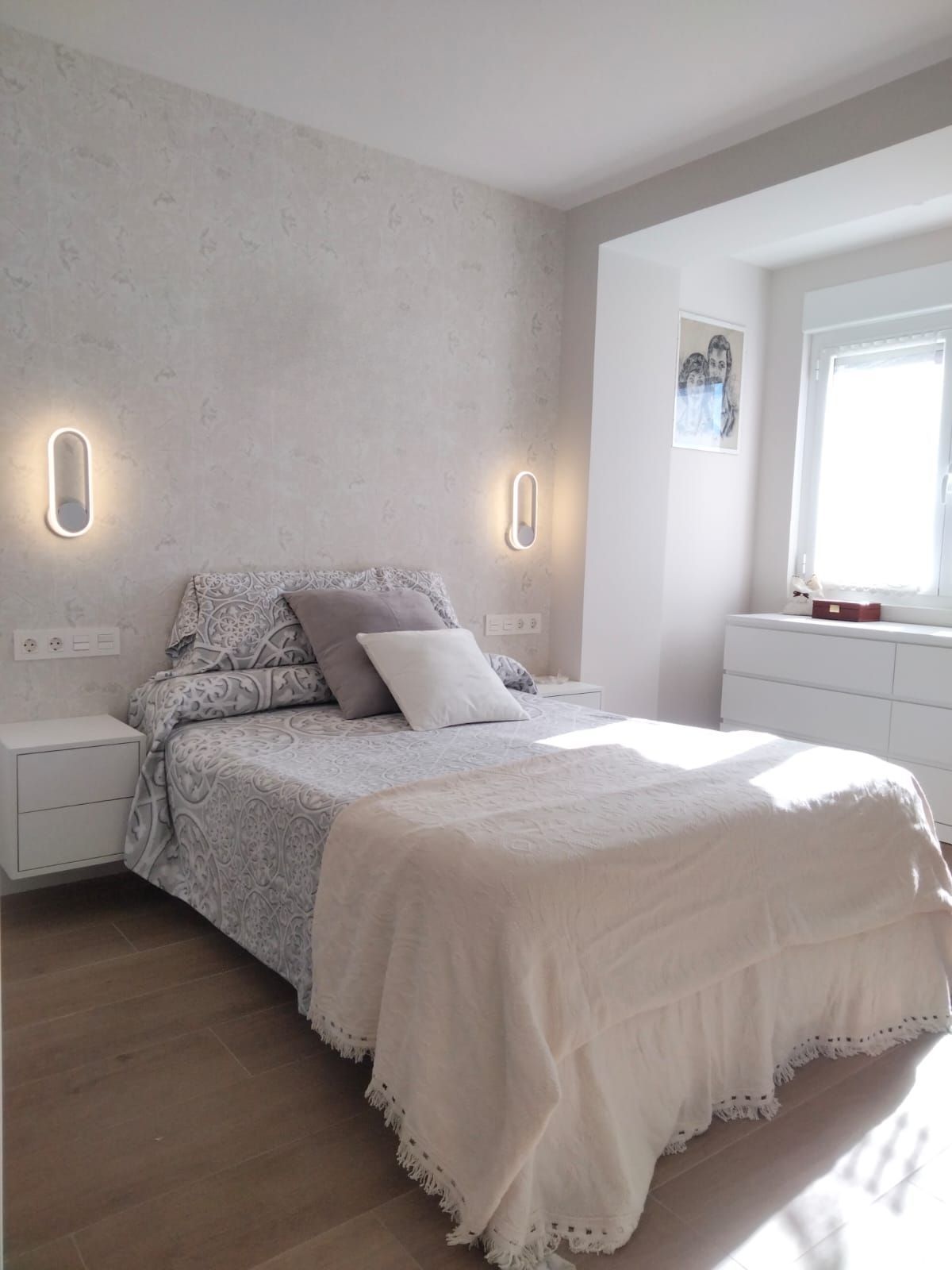 Un dormitorio con una cama grande y dos mesitas de noche.