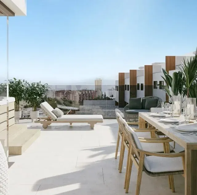 Un patio con mesa y sillas y vista al mar.