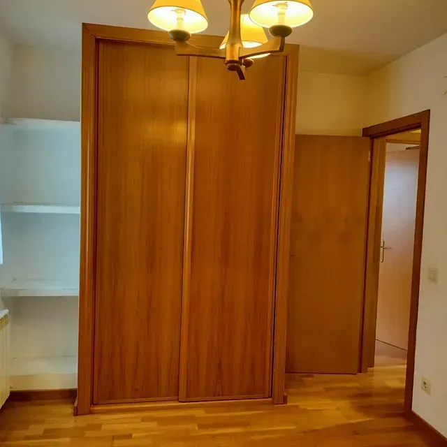 Un armario de madera con una lámpara de araña colgando del techo.