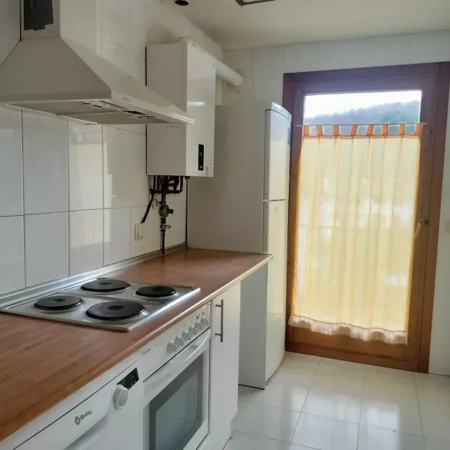 Una cocina con estufa, horno y refrigerador.