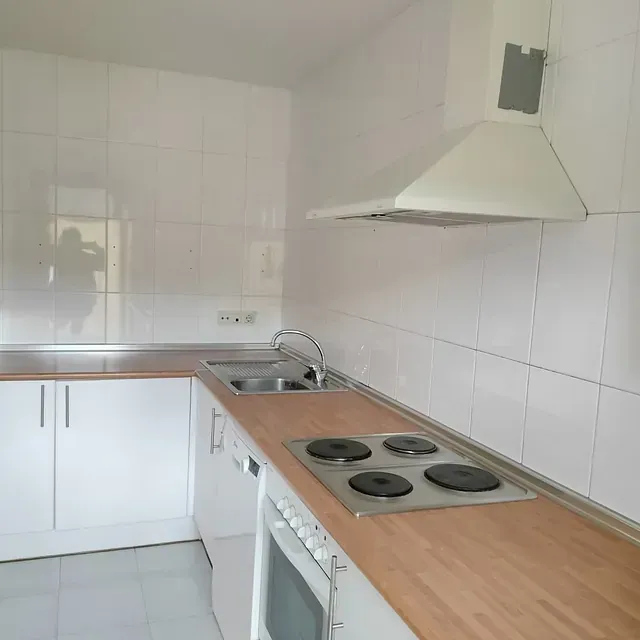 Una cocina con estufa, horno y fregadero.