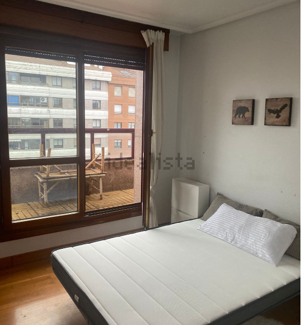 Un dormitorio con una cama y una ventana con la palabra ista en la pared.