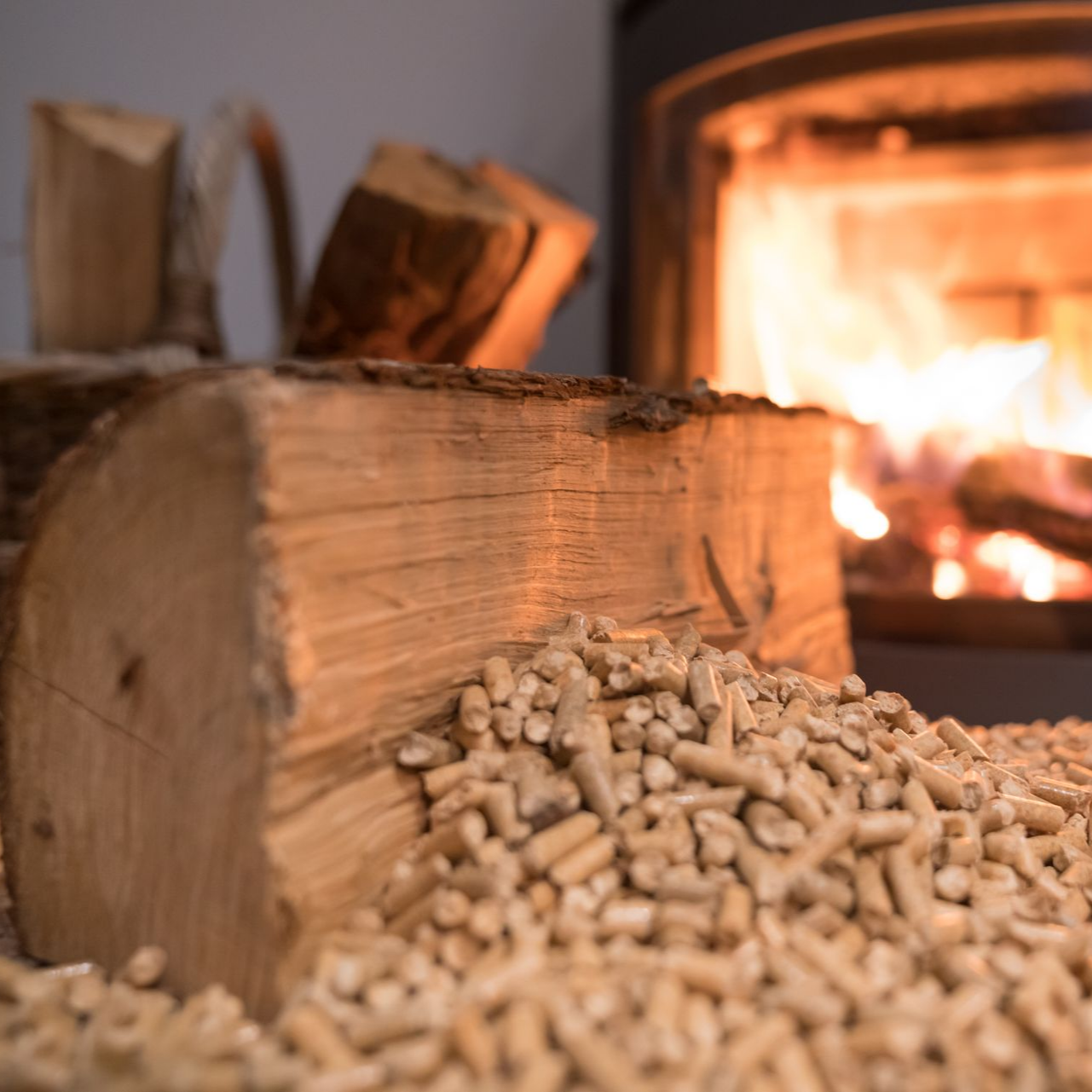 Des bûches de bois empilées près d'un feu de cheminée.