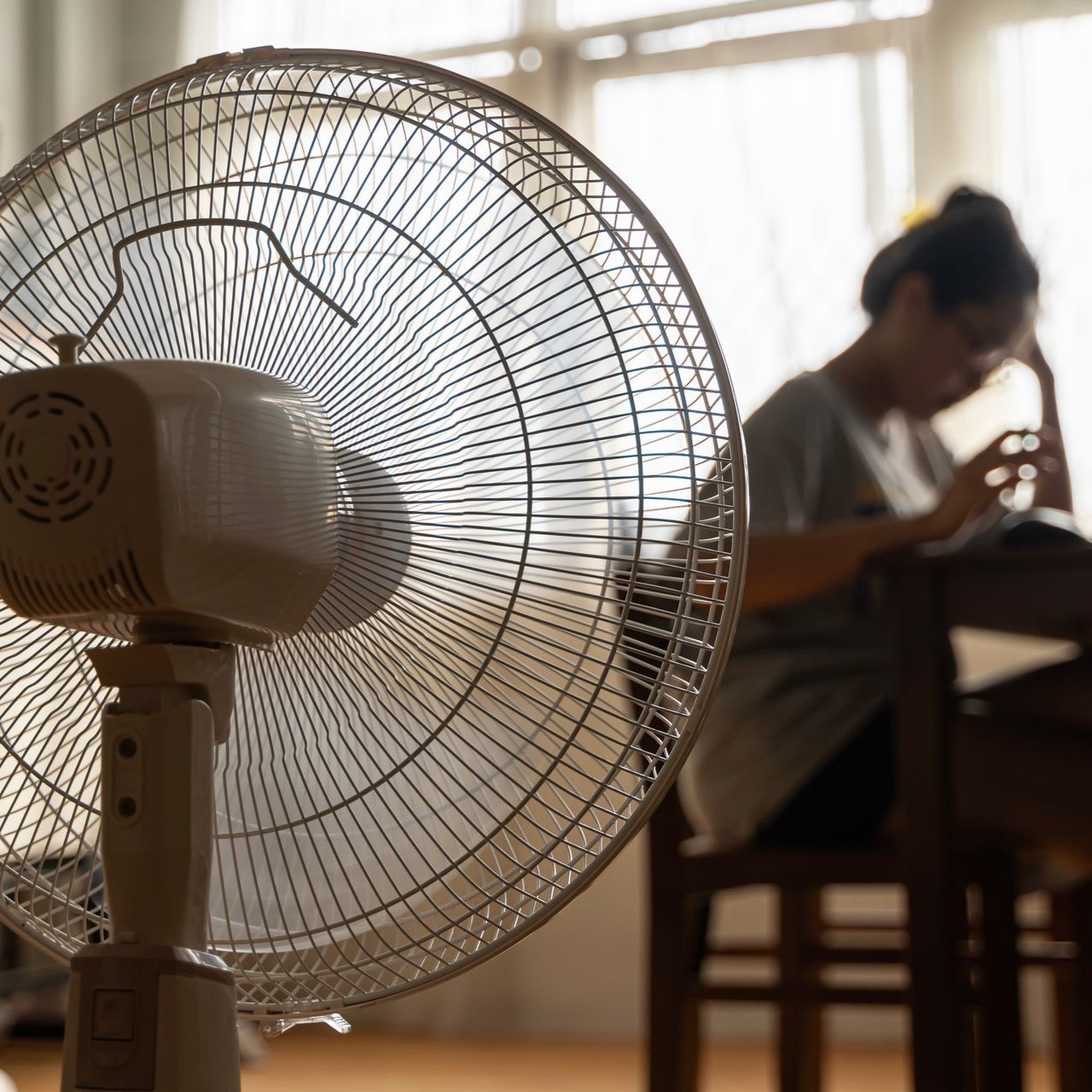 Une personne profitant d'un ventilateur.