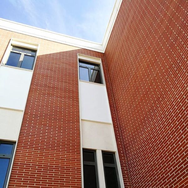 Mirando hacia arriba a un edificio de ladrillo con un cielo azul de fondo