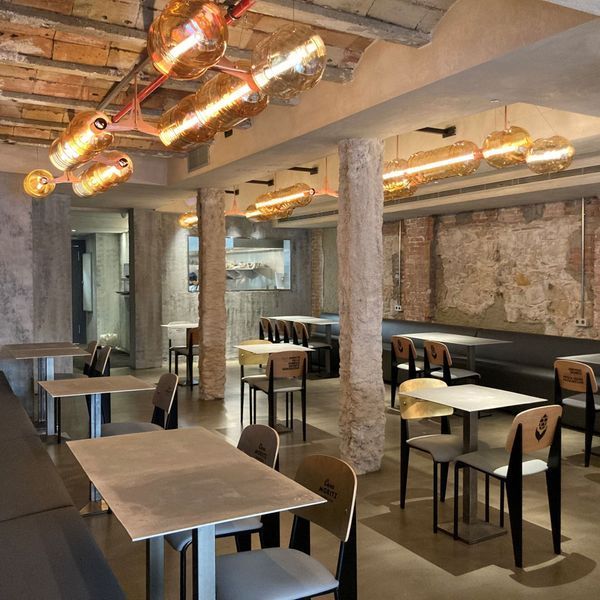 Un restaurante con mesas y sillas y un techo con luces.