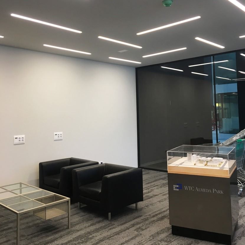 Una sala de espera con sillas y una mesa de cristal