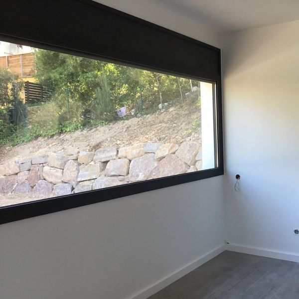 Una habitación vacía con una gran ventana que da a una pared de roca.