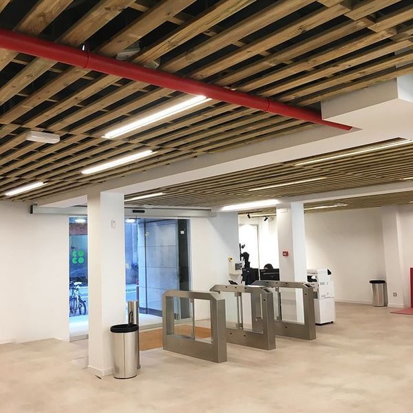 Una habitación grande con techo de madera y puertas de metal.