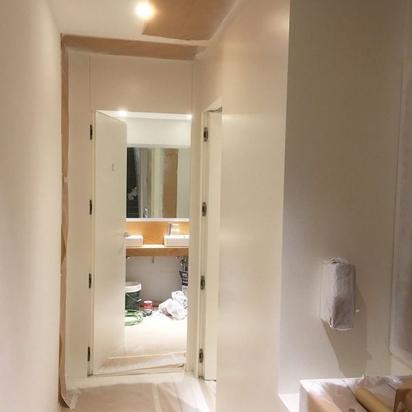 Un pasillo que conduce a un baño con lavabo y espejo.