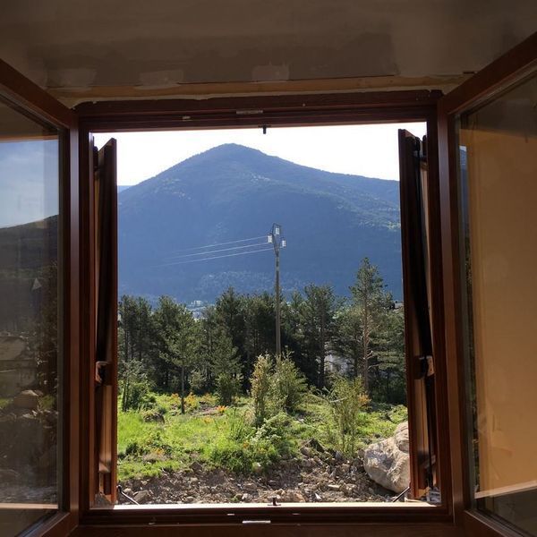 Una vista de una montaña a través de una ventana abierta