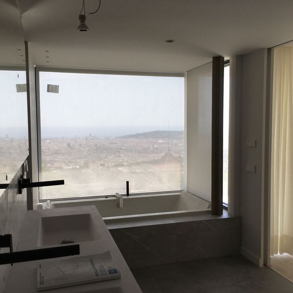 Un baño con una gran ventana y una bañera.