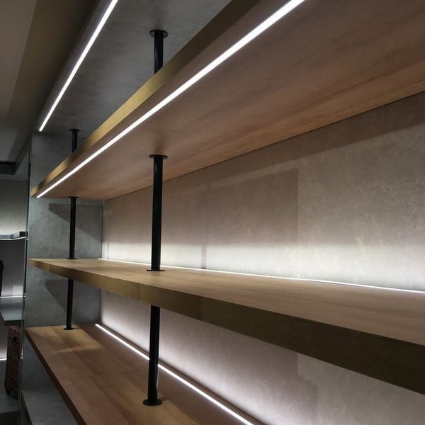 Una fila de estantes de madera con luces.