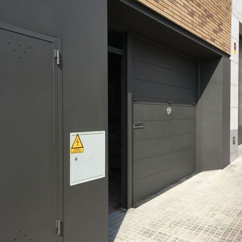 Una puerta de garaje negra con un triángulo amarillo.