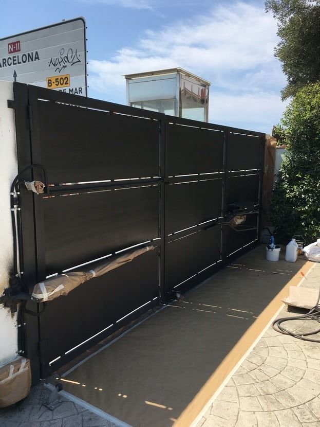 Una puerta negra con un cartel al fondo que dice Barcelona.